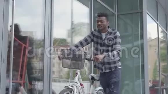 英俊自信的非裔美国人穿着休闲服装带着自行车靠近城市的商店橱窗那个家伙视频的预览图