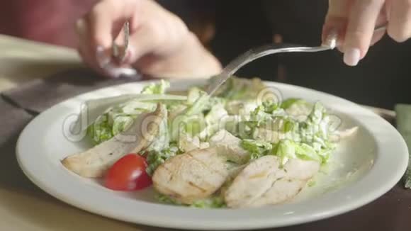 女人手里拿着凯撒沙拉在餐厅的桌子上健康饮食和节食理念视频的预览图