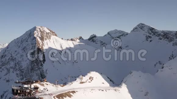 鸟瞰滑雪场雪山峰无人驾驶的滑雪电梯运送滑雪者和滑雪者在雪坡上的坐骑视频的预览图