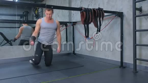 运动员把固定器放在腿上准备在健身房进行肌筋膜伸展视频的预览图