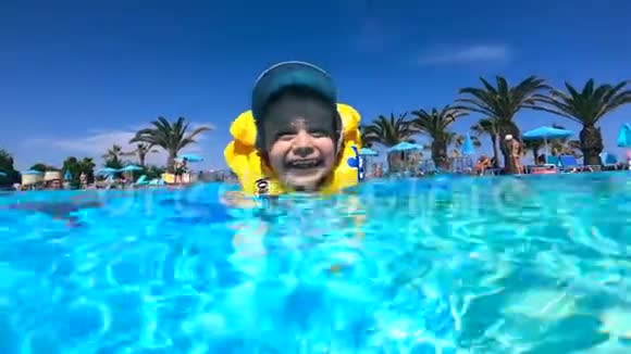 孩子在游泳池里游泳穿着充气背心暑假概念视频的预览图