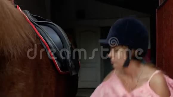 年轻的骑马女帽系紧马鞍上的带子特写4k4k视频视频的预览图