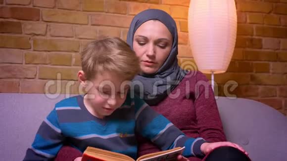 特写镜头集中的小男孩和他的穆斯林母亲在家专心读书视频的预览图