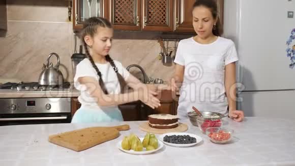 妈妈和女儿正在一起用奶油做手工蛋糕视频的预览图