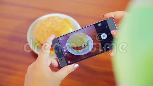 女性手拿着手机给汉堡拍照视频的预览图