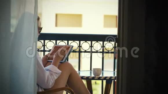 酒店阳台上有触摸板的年轻女子视频的预览图