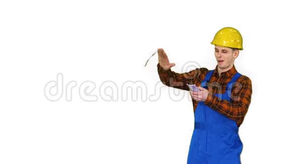 穿黄色安全帽的建筑工人在白色背景上向空中扔钱视频的预览图