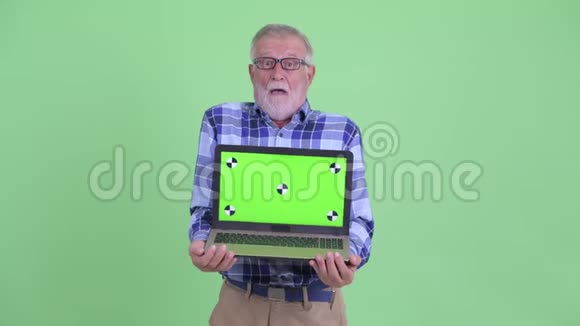 戴着笔记本电脑的快乐大胡子时髦男人看起来很惊讶视频的预览图