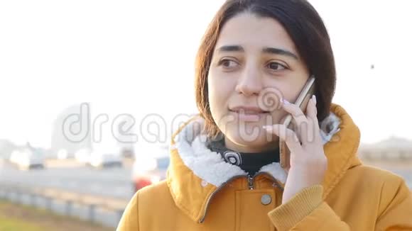 那个女孩在打电话美丽的黑发微笑不错城市喧嚣慢动作视频的预览图