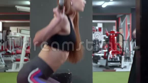 健美女孩用杠铃抽身体体育俱乐部里漂亮的女孩做不同的运动视频的预览图