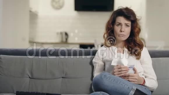 哭的女人在客厅看电视伤心女人擦脸的肖像视频的预览图