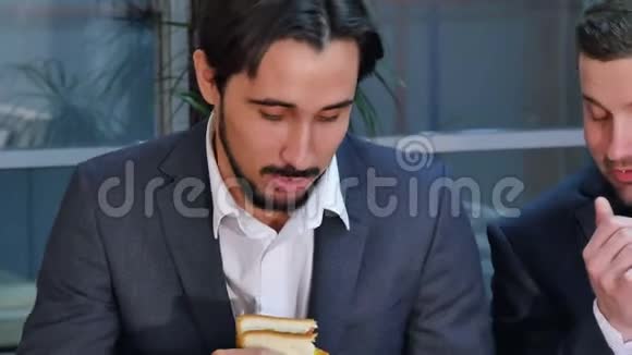 两个商人在办公室吃三明治视频的预览图