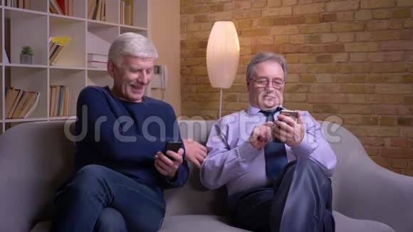 老人向他的朋友展示智能手机他们感到兴奋和快乐视频的预览图