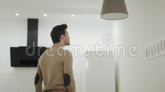 白人在开放式厨房拧开灯泡站在吊灯下的家伙视频的预览图