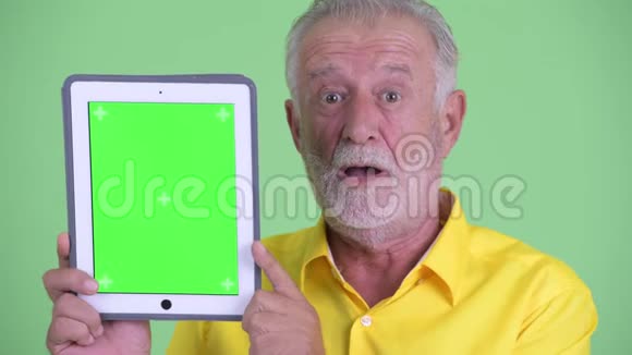大胡子的快乐商人展示数码平板电脑的脸视频的预览图