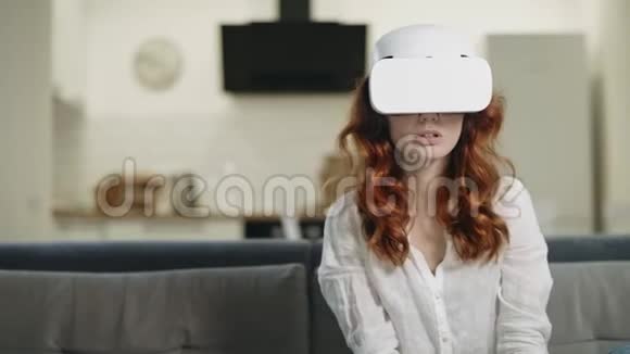 严肃的女人坐在沙发上戴着VR眼镜震惊的女人看着VR视频的预览图