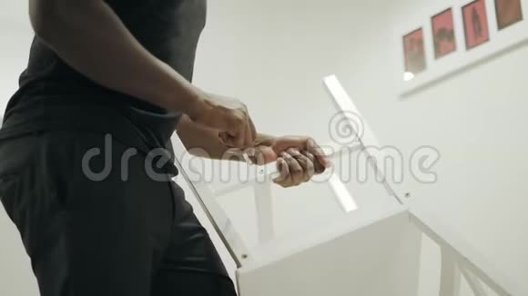 黑人男子把椅子放在厨房里特写手修木椅视频的预览图