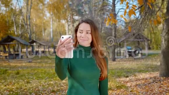 年轻漂亮的黑发女人从智能手机上向社交媒体传送视频视频的预览图
