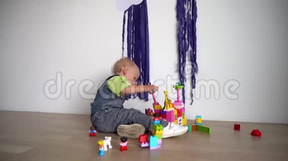 小可爱男孩用彩色积木搭建坐在木地板上万向节运动视频的预览图
