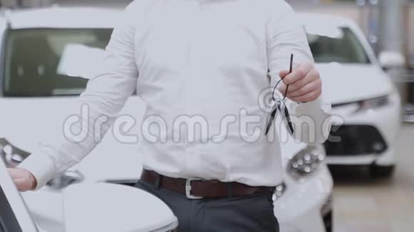 男人顾客拿着他新买的车钥匙有人拿着车钥匙站在经销商处视频的预览图