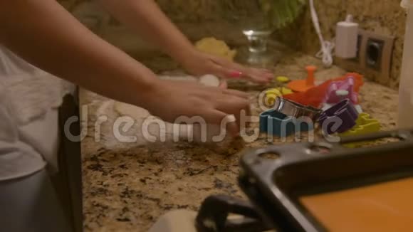 女用手用擀面杖在石制台面上用面粉擀制面团视频的预览图