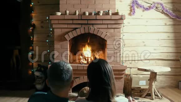 夫妻和狗坐在壁炉旁视频的预览图