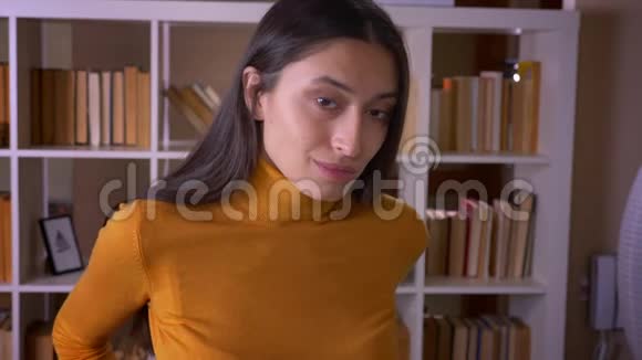 漂亮的黑发女老师看着镜头在图书馆感到尴尬和不舒服视频的预览图