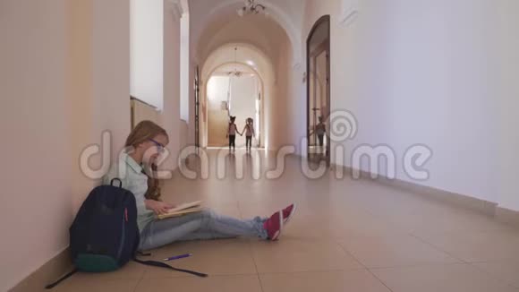 女孩坐在地板上看书准备上课视频的预览图