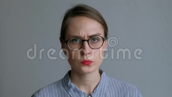 愤怒的年轻女孩戴着眼镜指着她的手指在白色背景上视频的预览图
