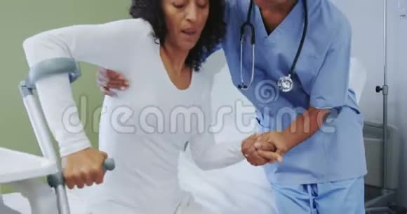 非裔美国女医生帮助女病人在医院病房行走的正面视角视频的预览图