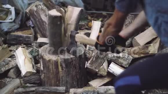 人们在户外缓慢地砍柴人手拿斧子樵夫用斧子砍树干视频的预览图