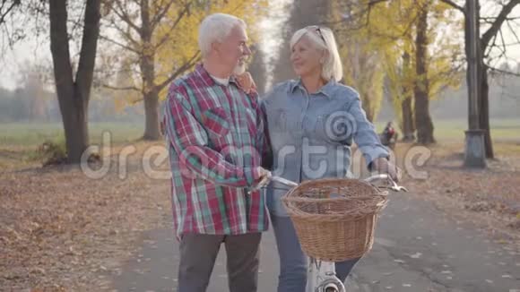 高加索族一家人骑着自行车站在雾蒙蒙的秋天公园里聊天快乐的退休老夫妇视频的预览图