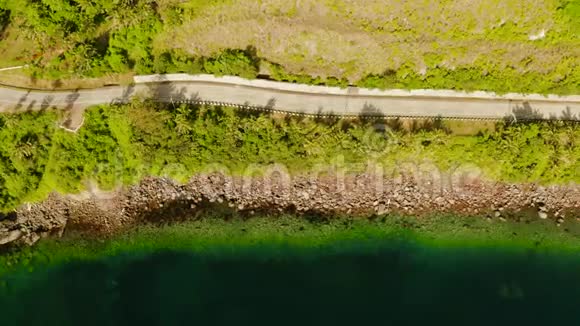 鸟瞰热带岛屿上的沿海公路沿海岸砼道路从上观视频的预览图