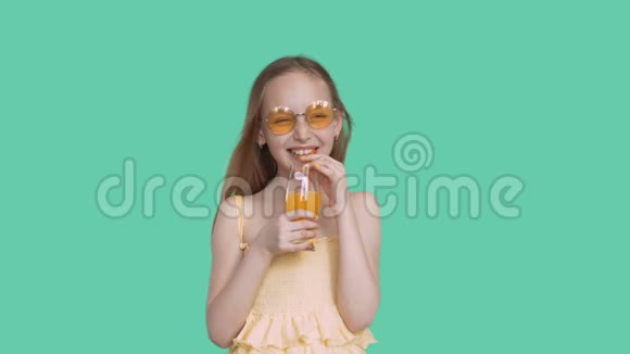 笑快乐的少女戴着眼镜穿着绿色屏幕上的果汁视频的预览图