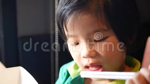 亚洲小女孩喜欢在餐馆里玩两根吸管品尝甜的碳酸水视频的预览图