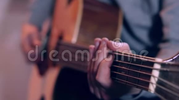 吉他手按着吉他的琴弦用慢动作合上男人的手指在吉他上弹奏音乐视频的预览图