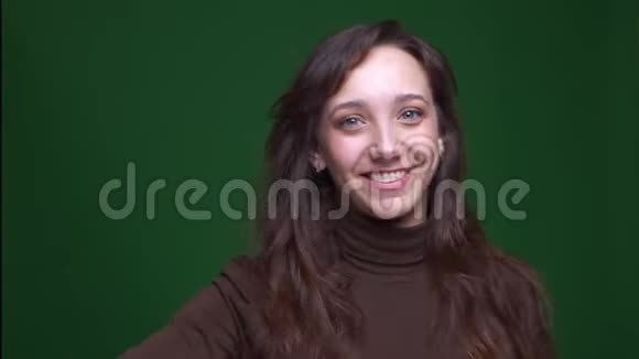 年轻的黑发女学生配音是快乐和满意的绿色背景视频的预览图