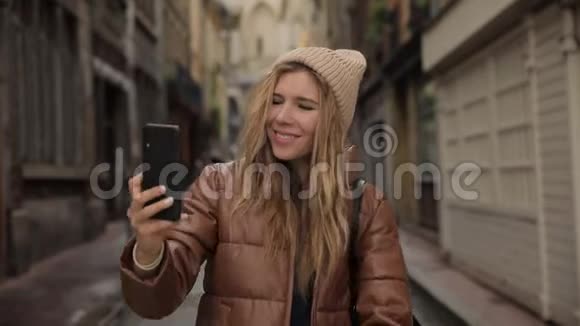 一位年轻时尚的年轻美丽的千禧年女子自拍的肖像显示了和平的标志和舌头微笑视频的预览图