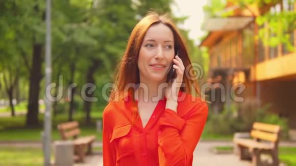一个红头发的女商人在移动电话旁交谈视频的预览图