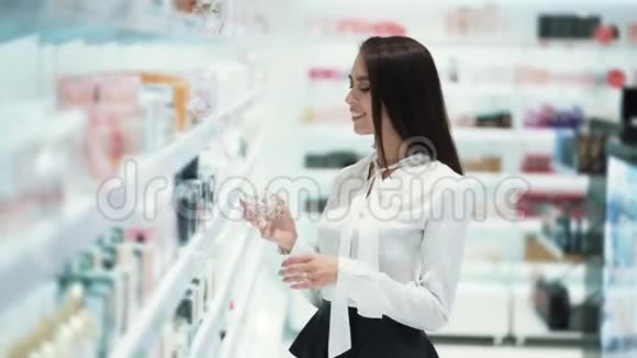 女人在化妆品店里选择香水在测试器上喷洒然后闻一闻视频的预览图