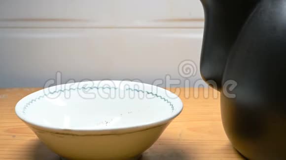 将热凉茶从搪瓷锅倒入碗中视频的预览图