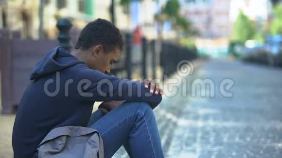 悲伤的混血少年坐在人行道上关系问题尴尬的年龄视频的预览图