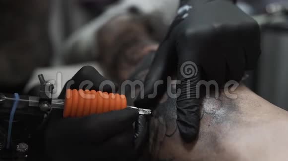 一个纹身艺术家的特写在一个男人腿上纹身很高的分辨率专业纹身师在工作室工作特写v视频的预览图