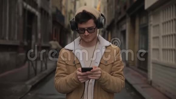 戴着太阳镜的英俊的欧洲白人年轻人与朋友家人的聊天以及智能手机上的短信联系在一起视频的预览图