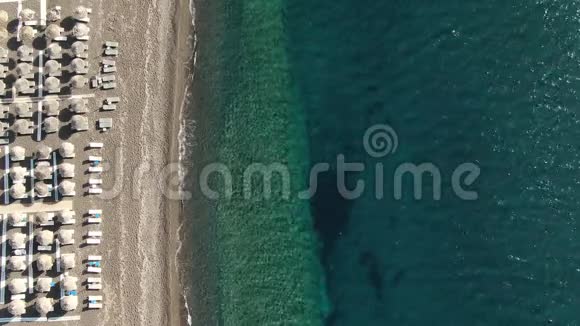 希腊圣托里尼绿松石海的海岸上有雨伞和日光浴床的海滩视频的预览图