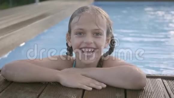 肖像可爱有趣的女孩扎着辫子笑着看着镜头孩子伸出大拇指看着外面视频的预览图