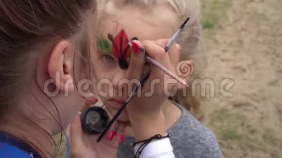 孩子们的脸画艺术家画小女孩像瓢虫万向节运动视频的预览图