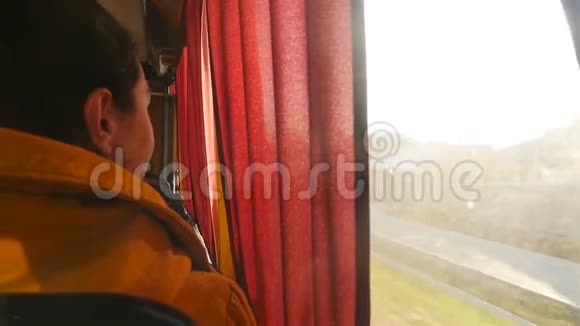 女孩骑在公共汽车上向窗外望去慢动作乘坐公共交通工具特写视频的预览图