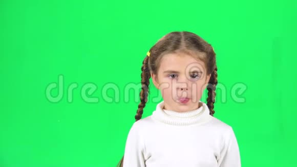 孩子玩和做滑稽的脸在绿色屏幕上显示舌头慢动作视频的预览图