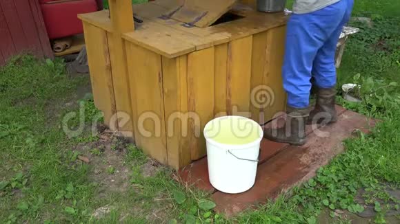 人们从花园里的乡村水井里拿出装满水的桶4K视频的预览图
